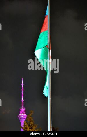 Aserbaidschanische Flagge beleuchtet in der Nacht vor dem lila beleuchteten Telekom-Turm in Baku, Hauptstadt von Aserbaidschan Stockfoto