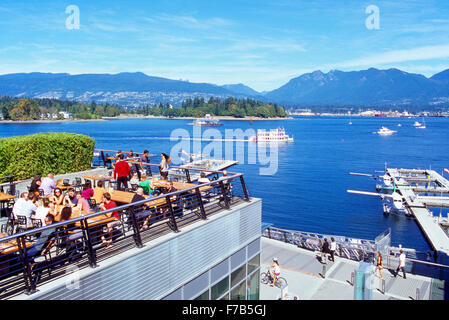 Vancouver, BC, Britisch-Kolumbien, Kanada - Restaurant im Freien mit Blick auf Coal Harbour, Burrard Inlet und North Shore Mountains Stockfoto