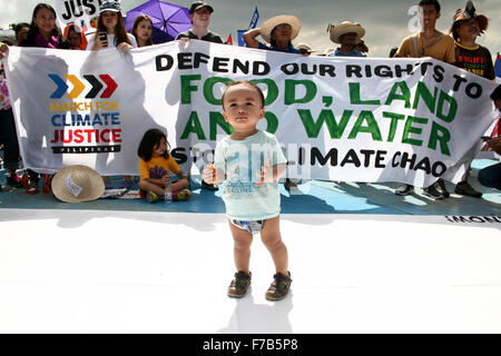 Philippinen. 28. November 2015. Ein junges Kind steht vor dem Publikum, wie sie es nennen, um ihr Recht auf Nahrung, Land und Wasser zu schützen. Hunderte von Menschen aus verschiedenen Bürgerinitiativen, marschierten die Quezon Kreis in Quezon City auf dem globalen Klima-Marsch teilzunehmen. Bildnachweis: J Gerard Seguia/ZUMA Draht/Alamy Live-Nachrichten Stockfoto