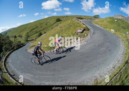 Radfahren in der Yorkshire Dales National Park, UK. Zwei Fahrer Klettern der Park Hautausschlag Spitzkehre biegen mit Steigungen zwischen 25-30 %. Stockfoto