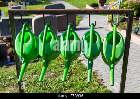 Gießkannen, hängen auf einem öffentlichen Friedhof, Stockfoto