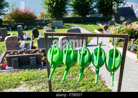 Gießkannen, hängen auf einem öffentlichen Friedhof, Stockfoto