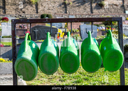 Gießkannen, hängen auf einem öffentlichen Friedhof, Stockfoto