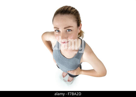 Schuss in ihre Sportkleidung, Hände auf den Hüften, stehend auf Skalen von oben-eine schlanke Frau genommen Stockfoto