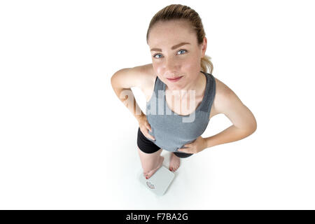 Schuss in ihre Sportkleidung, Hände auf den Hüften, stehend auf Skalen von oben-eine schlanke Frau genommen Stockfoto