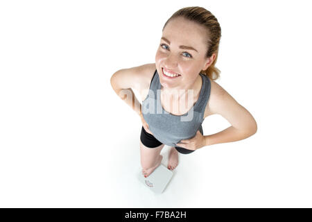 Schuss in ihre Sportkleidung, Hände auf den Hüften, stehend auf Skalen von oben-eine schlanke Frau genommen Stockfoto