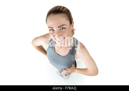 Schuss in ihre Sportkleidung, Hände auf den Hüften, stehend auf Skalen von oben-eine schlanke Frau genommen Stockfoto