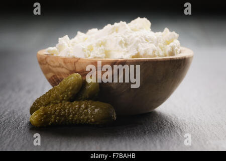 Ricotta-Käse in Holzschale mit marinieren Gurken Stockfoto