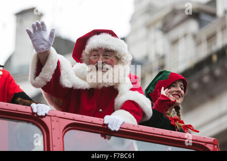 London, UK. 28. November 2015. Der Weihnachtsmann reist mit einer Elfe auf einem Doppeldecker-Bus. Die konstituierenden Hamleys Weihnachten Spielzeug Parade findet entlang der Regent Street, die verkehrsfreie für den Tag ging. Die Parade organisiert von den weltberühmten Spielzeugladen Hamleys über 50 der landesweit beliebtesten Kinder Charaktere zusammen mit 400 Animateure, eine Blaskapelle und Riesenballons gekennzeichnet. Die Parade ist Macys jährliche Thanksgiving Parade in New York nachempfunden. Bildnachweis: Lebendige Bilder/Alamy Live-Nachrichten Stockfoto