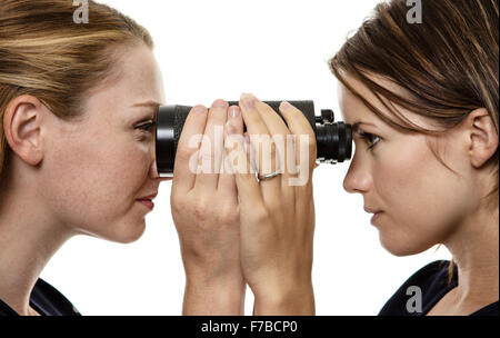 Zwei Business-Frau auf der Suche durch die gleiche Fernglas Stockfoto