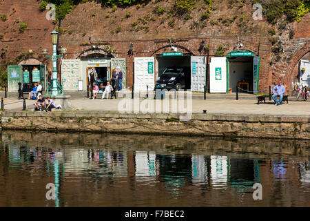 Geschäfte in der historischen alten Kellern mit Fluss Exe Reflexionen und Menschen, auf einer sonnigen Herbstnachmittag, Kai Exeter, Devon. Stockfoto