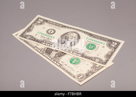 Amerikanische ein bis zwei Dollar Geldscheine auf grau Stockfoto