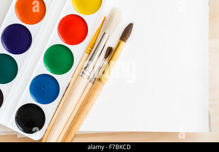 Neue Aquarelle, sauber Bürsten und ein leeres Album auf eine Holzoberfläche Stockfoto