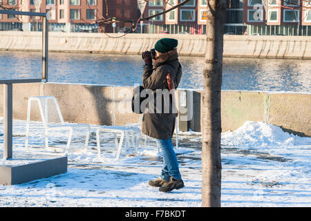 Moskau, Russland. Samstag, 28. November 2015. Kalt, aber ruhigen und sonnigen Wochenende in Moskau, Russland. Die Temperatur von-2 Grad C (28,4 Grad F), kein Wind und viel Sonne nach vielen Tagen von trübem Wetter. Viele Leute zu Hause bleiben, aber einige es vorziehen, von spazieren gehen, tun einige Skaten im Gorki Park. Nicht identifizierte junge Frau nimmt ein Foto auf dem Schnee überdachten Promenade Damm Museon Park der Künste. Bildnachweis: Alex Bilder/Alamy Live-Nachrichten Stockfoto