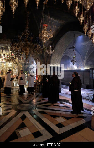 Katholischen Klerus betet am Altar der Kreuzigung in der Kalvarienberg oder Golgotha gilt traditionell als Ort der Kreuzigung Jesu im Inneren der Kirche des heiligen Sepulchre Altstadt Ost-Jerusalem Israel Stockfoto