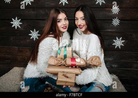 Zwei schöne Mädchen bieten Geschenke für Kamera Stockfoto