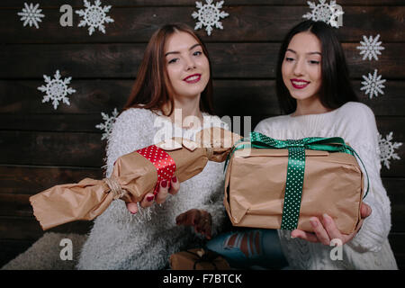 Zwei schöne Mädchen bieten Geschenke für Kamera Stockfoto