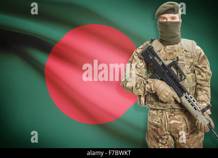 Soldat mit Maschinengewehr mit Nationalflagge auf Hintergrund - Bangladesch Stockfoto