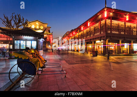 Rikschas warten auf Kunden-Touristen in der Fußgängerzone der Stadt Nanjing in China nach Sonnenuntergang auf einer belebten beleuchtet Stockfoto