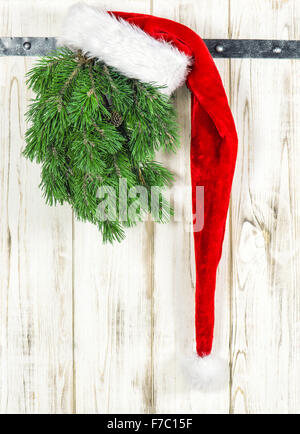 Red Hat und grünen Weihnachtsbaum Zweig. Vintage-Stil Dekoration Stockfoto