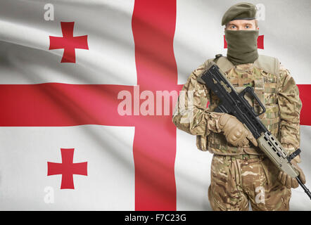 Soldat mit Maschinengewehr mit Nationalflagge auf Hintergrund - Georgien Stockfoto