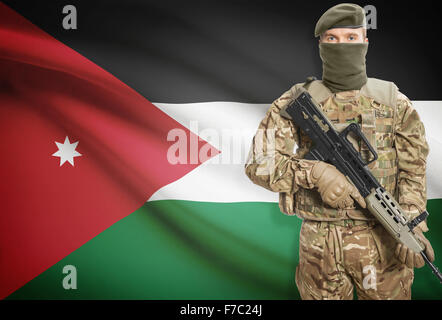 Soldat mit Maschinengewehr mit Nationalflagge auf Hintergrund - Jordanien Stockfoto