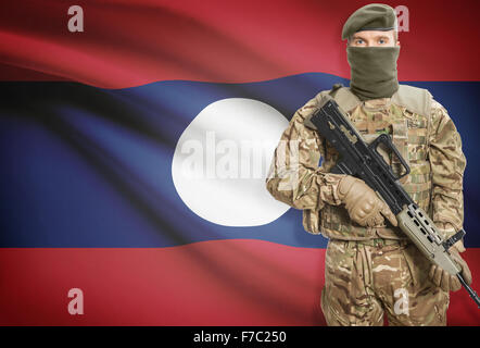 Soldat mit Maschinengewehr mit Nationalflagge auf Hintergrund - Laos Stockfoto