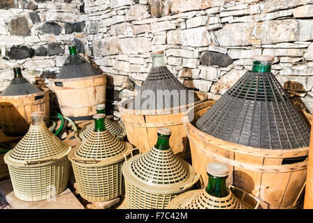 Korbflaschen Wein in ein Steinkeller. Stockfoto