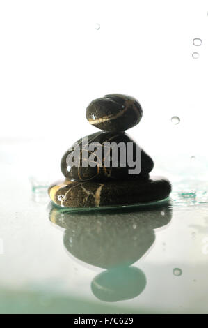 isolierte nass Zen Steinen mit Spritzwasser Tropfen vertreten Konzept der natürlichen Balance und Harmonie Stockfoto