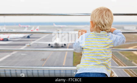 Kleinen Jungen warten auf boarding, Flug im Flughafen-Transit-Halle und Blick auf Flugzeug in der Nähe von Abflug-gate Stockfoto