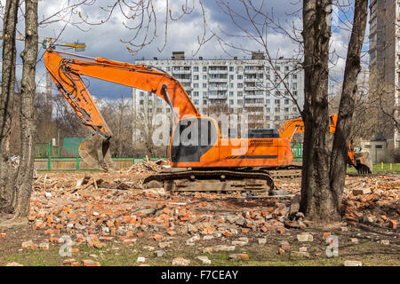Raupenbagger entfernt Bauschutt nach Gebäudeabbruch Stockfoto