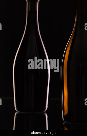 Zwei verschiedene Flaschen Wein auf das schwarze Glas. Stockfoto