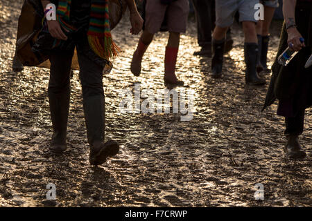 Festivalbesucher geht durch Schlamm Gummistiefel tragen eine Glastonbury Musikfestival Stockfoto