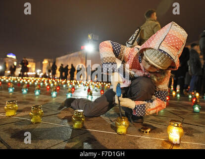 Kiew, Ukraine. 28. November 2015. Ukrainischen Mädchen Licht Kerze während einer Gedenkfeier am Platz Unabhängigkeit. Ukrainer Kerzen, einen Tag der Erinnerung für die Opfer des Holodomor 1932-1933 zu markieren. Der Holodomor war einer von Menschen verursachten Hungersnot provoziert durch sowjetischen Diktator Josef Stalin. Das Ergebnis war der Tod um mehr als 5 Millionen Ukrainer. © Vasyl Shevchenko/Pacific Press/Alamy Live-Nachrichten Stockfoto