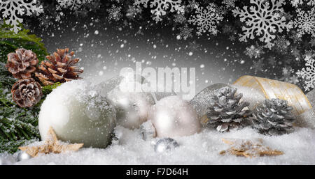 Elegante Weihnachtsarrangement mit schöne Bänder, silbernen Kegel, Kugeln, viel Schnee und ornamentalen große Schneeflocken im Dunkeln Stockfoto