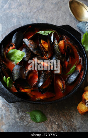 schwarze Muscheln in roten Tomaten-Wein-Sauce, Essen Nahaufnahme Stockfoto