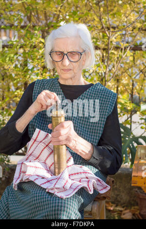 Oma Kaffee auf einem Vintage Holz Kaffeemühle mahlen Stockfoto