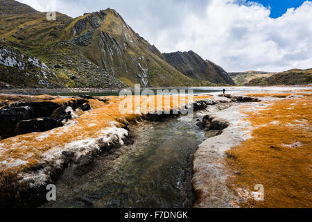 Quengococha See in den Bergen in der Nähe von Cajabamba in Cajamarca in Peru mit einer orange Algen über Niedrigwasser Seeufer Stockfoto