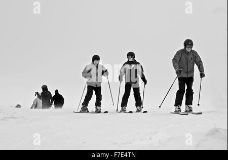 Skifahrer tragen volle Winterkleidung auf Cairngorm Mountain in kalten und windigen Wetterbedingungen bei schlechter Sicht. Stockfoto