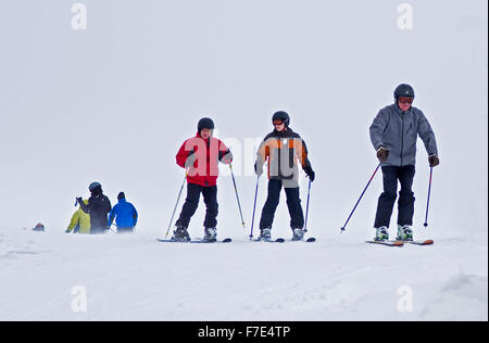 Skifahrer tragen volle Winterkleidung auf Cairngorm Mountain in kalten und windigen Wetterbedingungen bei schlechter Sicht. Stockfoto