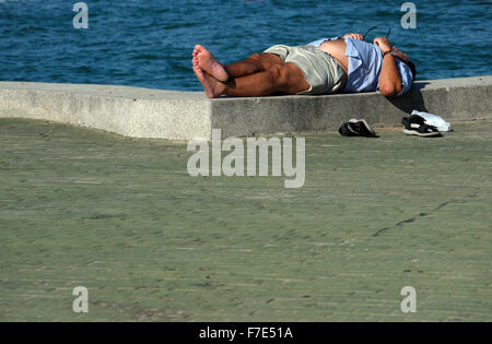 Halb bekleidet Männer mittleren Alters in der Sonne auf einem Meer Wand- und Gehweg in Pattaya Thailand Stockfoto