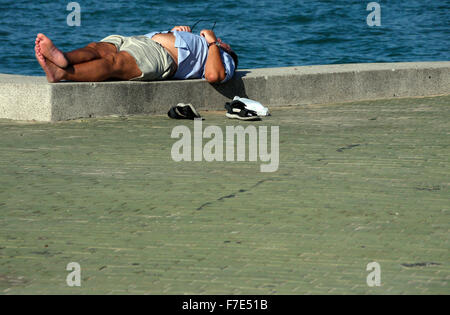 Halb bekleidet Männer mittleren Alters in der Sonne auf einem Meer Wand- und Gehweg in Pattaya Thailand Stockfoto