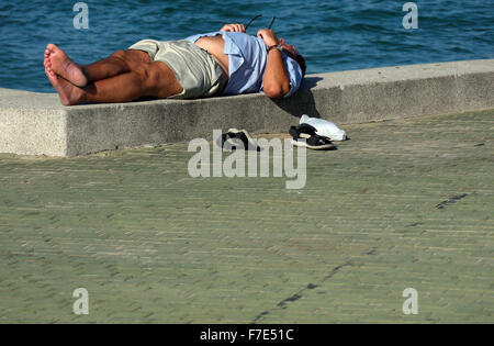 Halb bekleidet Männer mittleren Alters in der Sonne auf einem Meer Wand- und Gehweg in Pattaya Thailand Stockfoto