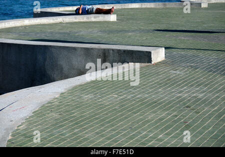 Halb bekleidet Männer mittleren Alters in der Sonne auf einem Meer Wand- und Gehweg in Pattaya Thailand Stockfoto