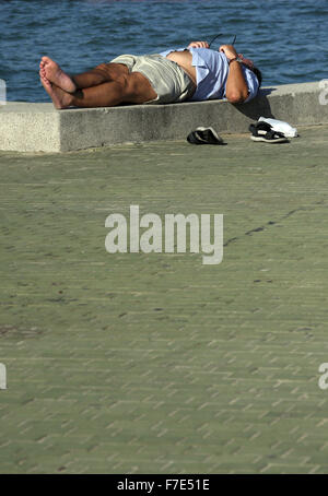 Halb bekleidet Männer mittleren Alters in der Sonne auf einem Meer Wand- und Gehweg in Pattaya Thailand Stockfoto