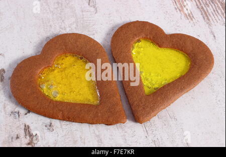 Frische hausgemachte dekoriert Glasmalerei Lebkuchen in Form von Herzen, Weihnachtsplätzchen auf alten weißen hölzernen Hintergrund, xmas Stockfoto