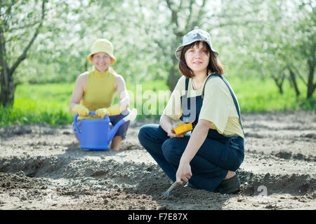 Zwei Frauen sät Samen im Boden im Garten Stockfoto