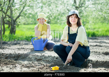 Zwei Frauen sät Samen im Boden im Garten Stockfoto