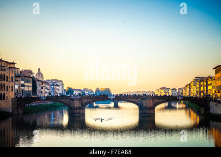 Die erstaunliche Ponte Vecchio über den Arno in Florenz, Italien. Unter der Brücke ein Kerl Rudern Stockfoto