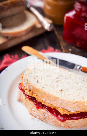 Nahaufnahme eines Erdnussbutter und Marmelade Sandwich auf einem rustikalen Tisch. Stockfoto